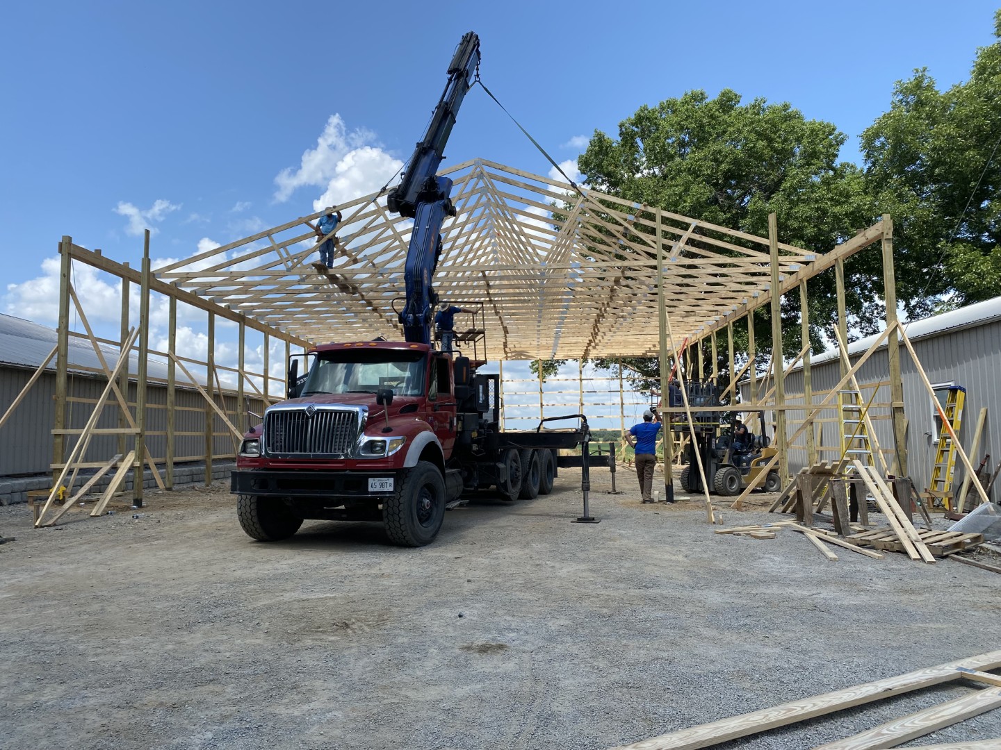 crane installing wooden roof trusses