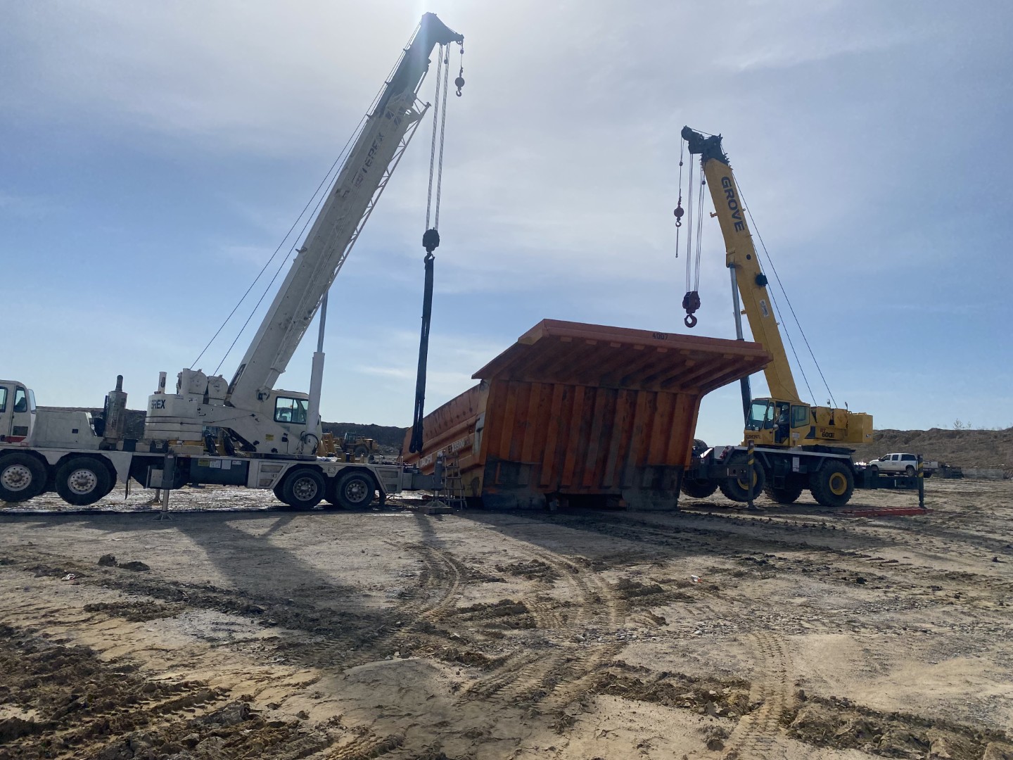 two cranes servicing mining dump bed